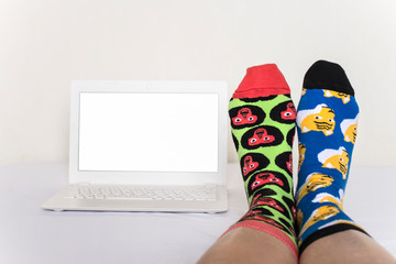 funny female legs in different socks with animals and laptop