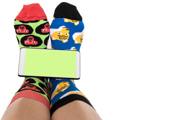 funny legs in different socks hold a smartphone on a white background