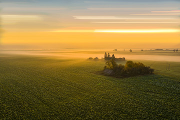 Aerial: Dreamy autumn sunrise above the farmhouse