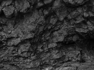 Black stone grunge texture. Dark gray rock background. Mountain close-up. Black rock backdrop.