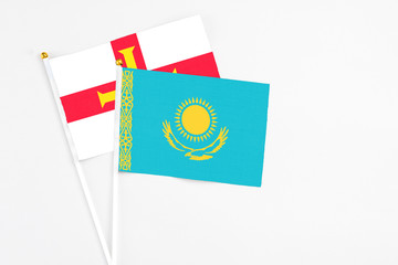 Kazakhstan and Guernsey stick flags on white background. High quality fabric, miniature national flag. Peaceful global concept.White floor for copy space.