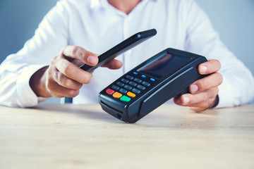 man hand phone with payment terminal