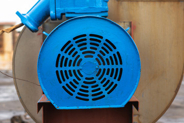 Old stationary engine cleaned and painted blue. engine exhaust system. factory roof