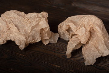 crumpled parchment papers on a burnt wooden table