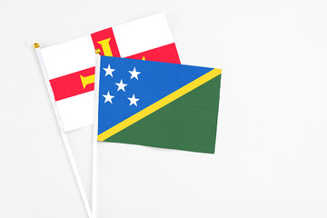Solomon Islands and Guernsey stick flags on white background. High quality fabric, miniature...