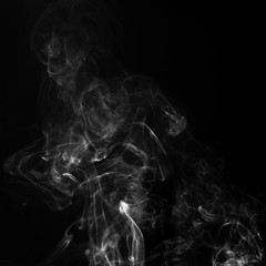 Gray smoke on a black background. Realistic incense smoke captured with a flash.