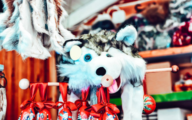 Market stall with traditional souvenirs such as husky dog toy in winter Rovaniemi, Lapland, in Finland. Street Xmas holiday fair. Advent Decoration and Stalls with Crafts Items on Bazaar
