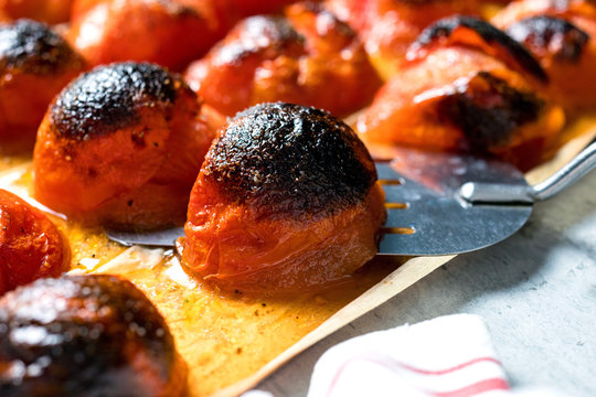 Close up of baked tomatoes on baking sheet