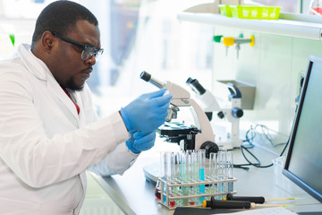 African-american medical doctor working in research lab. Science assistant making pharmaceutical...