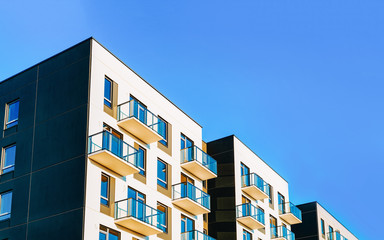 Fragment of Modern residential apartment with flat buildings exterior. Detail of New luxury house and home complex. Part of City Real estate property and condo architecture. Copy space. Blue sky