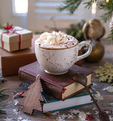 Closeup white cup of coffee on the festive table and gift boxes on wooden background. Christmas or New Year
