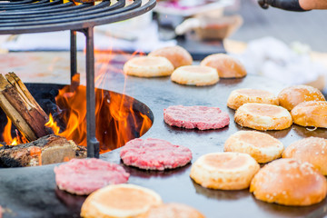 raw burger beef patties on the grill. Open fire on the barbecue