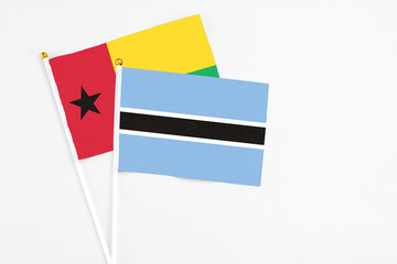 Botswana and Guinea Bissau stick flags on white background. High quality fabric, miniature national flag. Peaceful global concept.White floor for copy space.