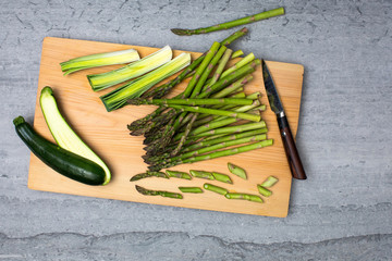 Overhead view of green vegetables on wooden cutting board