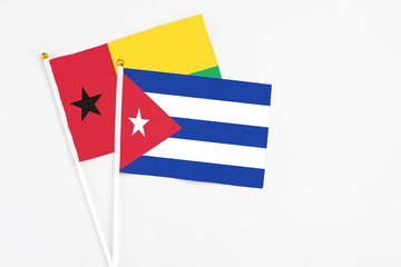 Cuba and Guinea Bissau stick flags on white background. High quality fabric, miniature national flag. Peaceful global concept.White floor for copy space.