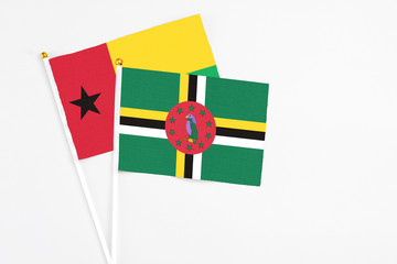 Dominica and Guinea Bissau stick flags on white background. High quality fabric, miniature national...