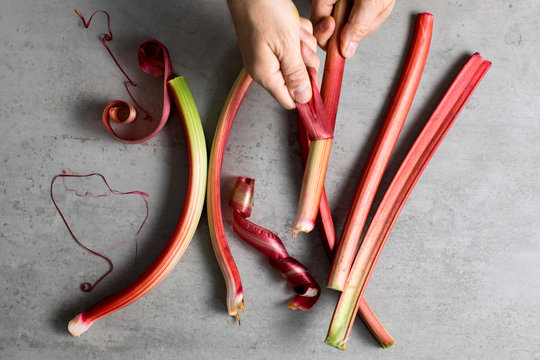 Overhead view of hands peeling rhubarb