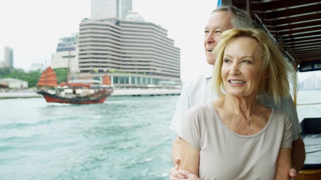 Senior couple passing red sail Junk Hong Kong 