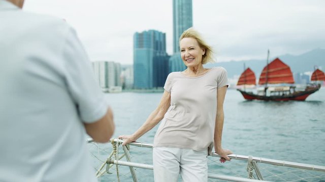 Happy Caucasian couple taking pictures Hong Kong harbor