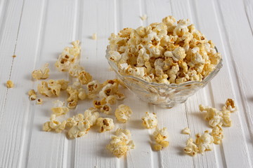 Salt popcorn on the wooden table, selective focus. Horizontal. Copy space.