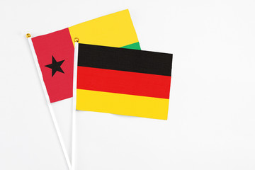Germany and Guinea Bissau stick flags on white background. High quality fabric, miniature national flag. Peaceful global concept.White floor for copy space.