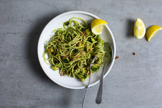Overhead view of spaghetti with zucchini, parsley pesto and bottarga