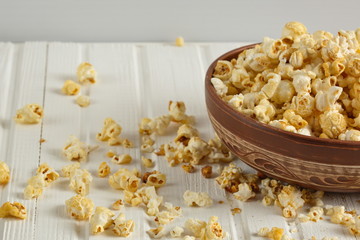 Salt popcorn on the wooden table, selective focus. Horizontal. Copy space.