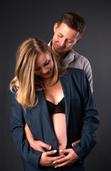 man and woman put their hands to their stomach and listen to how their child is there. look at the stomach