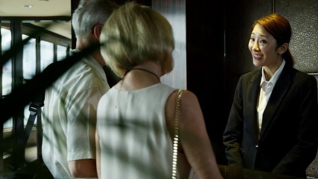 Retired Caucasian couple checking into Hong Kong hotel