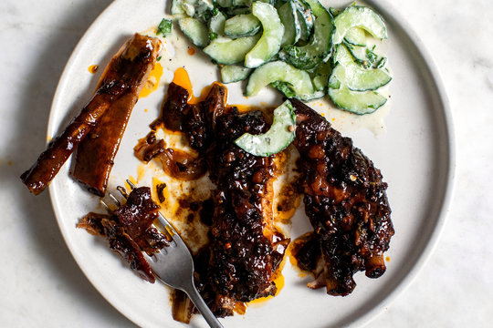 Overhead view of sweet and spicy ribs with cucumber raita