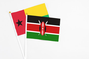 Kenya and Guinea Bissau stick flags on white background. High quality fabric, miniature national flag. Peaceful global concept.White floor for copy space.