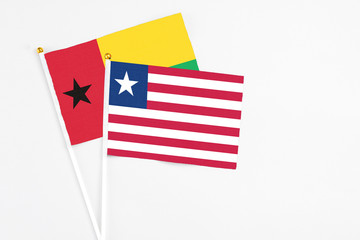 Liberia and Guinea Bissau stick flags on white background. High quality fabric, miniature national flag. Peaceful global concept.White floor for copy space.