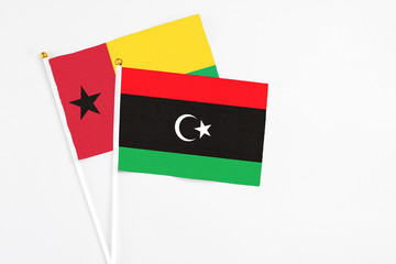 Libya and Guinea Bissau stick flags on white background. High quality fabric, miniature national flag. Peaceful global concept.White floor for copy space.