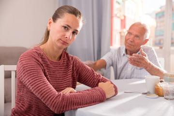 Upset daughter and senior man discussing, quarrel at home