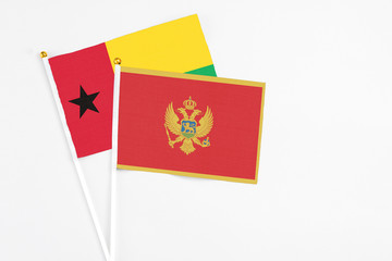 Montenegro and Guinea Bissau stick flags on white background. High quality fabric, miniature national flag. Peaceful global concept.White floor for copy space.