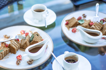 A piece of honey cake in the restaurant on the table. Beautiful sweet dessert with salted caramel and espresso coffee. Belarus, Minsk.