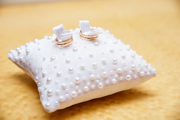 Wedding rings on a white small pillow