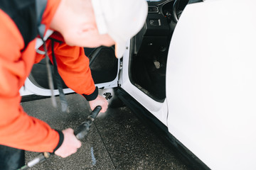 Obraz premium Male hands cleans car interior on carwash station