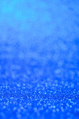 Vertical winter festive shine sparkle glitter macro concept in blue color. Bokeh defocus disco effect.