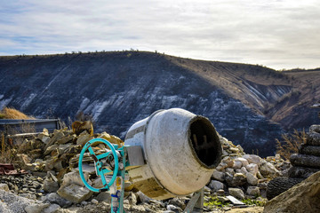 Electric concrete mixer. Construction site on the background of the mountain. Close-up. Selective...