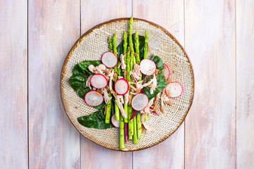Asparagus salad with chicken, radish, beet leafs and rye crumb