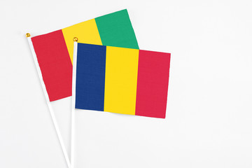 Chad and Guinea stick flags on white background. High quality fabric, miniature national flag. Peaceful global concept.White floor for copy space.