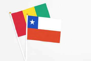 Chile and Guinea stick flags on white background. High quality fabric, miniature national flag. Peaceful global concept.White floor for copy space.