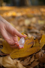 Female hand with orange manicure holding transparent violet amethyst yoni egg for vumfit,...