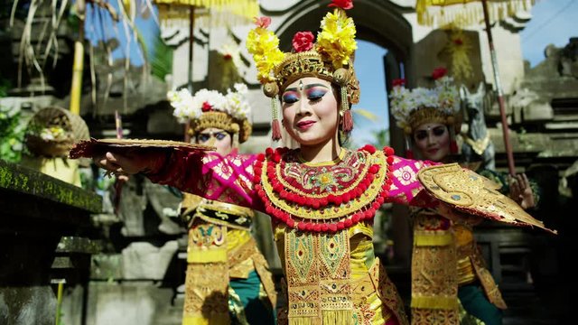 Ornate jewelled hand fans displayed by Balinese female