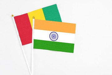 India and Guinea stick flags on white background. High quality fabric, miniature national flag. Peaceful global concept.White floor for copy space.
