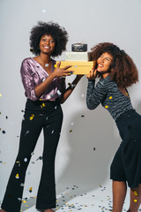 Attractive Black African American women carrying gifts and playing. Party time.