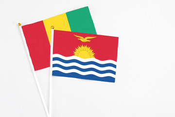 Kiribati and Guinea stick flags on white background. High quality fabric, miniature national flag. Peaceful global concept.White floor for copy space.