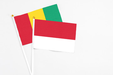 Monaco and Guinea stick flags on white background. High quality fabric, miniature national flag. Peaceful global concept.White floor for copy space.