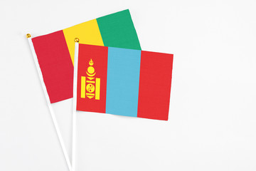 Mongolia and Guinea stick flags on white background. High quality fabric, miniature national flag. Peaceful global concept.White floor for copy space.